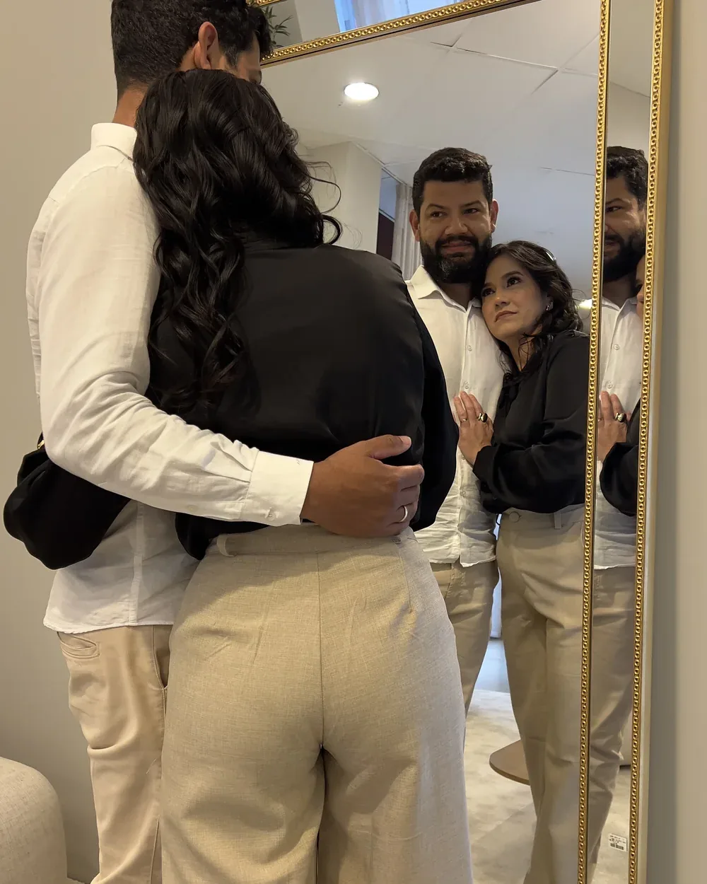 Luiz Paulo e Alê abraçados diante de um espelho, seus reflexos ao lado